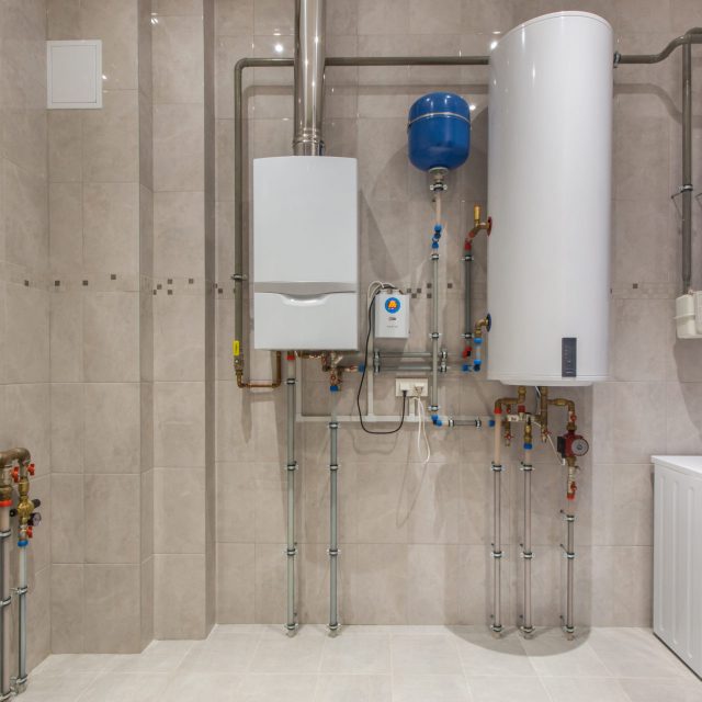 Wall hung gas boiler and electric water heater in boiler room